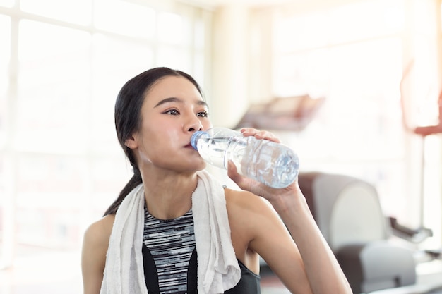 Água potável asiática nova consideravelmente desportiva da mulher após o exercício do treinamento do esporte