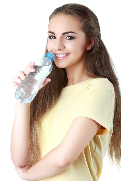 Água potável da jovem mulher no fundo branco
