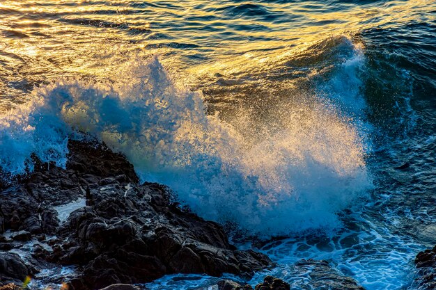 Água salpicando com o choque de ondas contra as rochas na cidade de Salvador, na Bahia