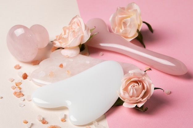 Gua sha de alto ângulo e arranjo de flores pequenas
