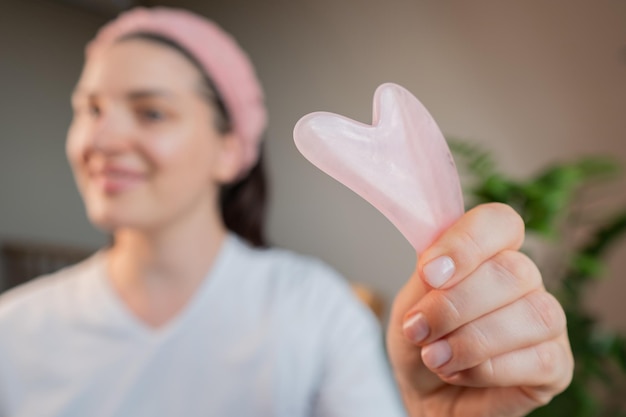Gua sha morgendliche Massage Frau kümmert sich um ihre Haut, indem sie die Gesichtskontur hebt