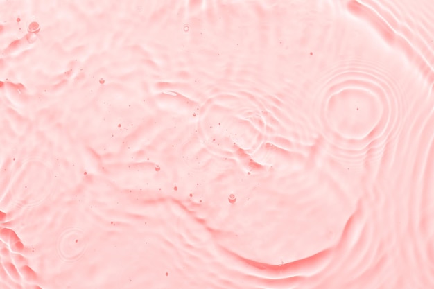 Água superfície rosa fundo abstrato ondas e ondulações textura de hidratante aqua cosmético com bolhas