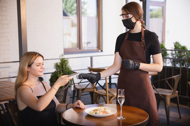 Água trabalhando com máscara facial em restaurante, surto de coronavírus