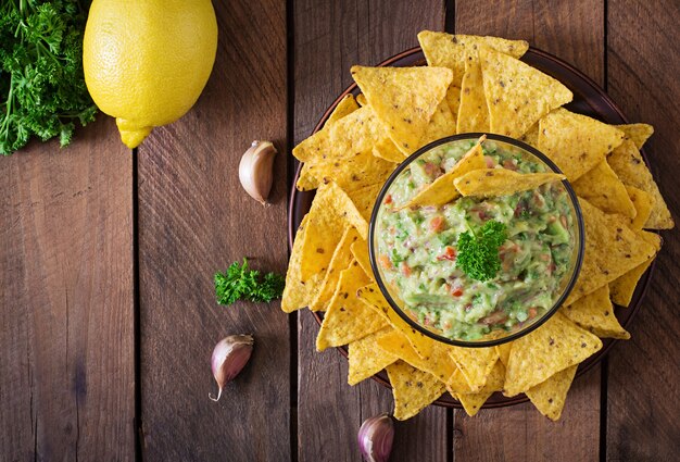 Guacamole avocado, limette, tomate, zwiebel und koriander, serviert mit nachos - traditioneller mexikanischer snack