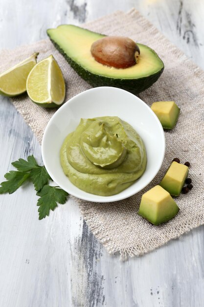 Guacamole fresco en un tazón sobre mesa de madera