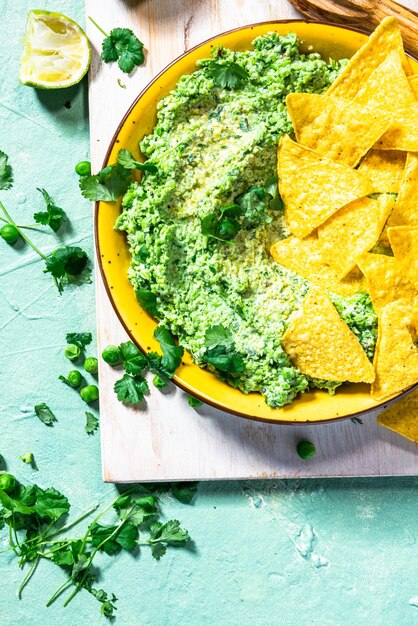 Guacamole de guisantes verdes con nachos Alternativa de aguacate comida saludable para fiestas