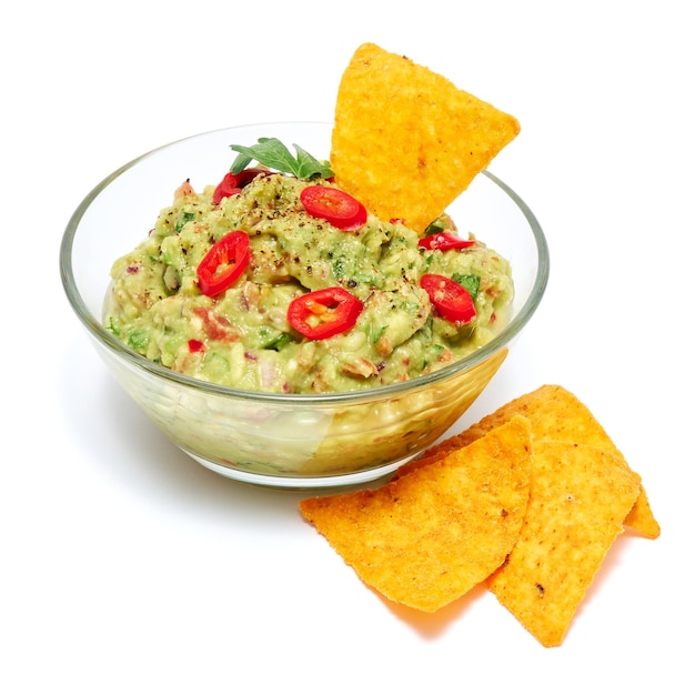 Guacamole orgánico vegetariano saludable Salsa mexicana servida en un tazón de vidrio con nachos o chips de tortilla aislados en fondo blanco