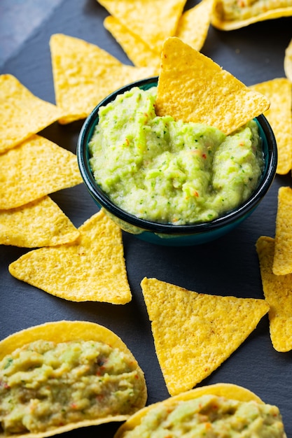 Guacamole- und Nachos-Chips auf dunklem Hintergrund