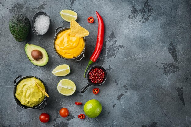 Guacamole verde e molho de queijo amarelo para tacos mexicanos tradicionais na vista superior de fundo cinza ou postura plana com espaço de cópia para texto