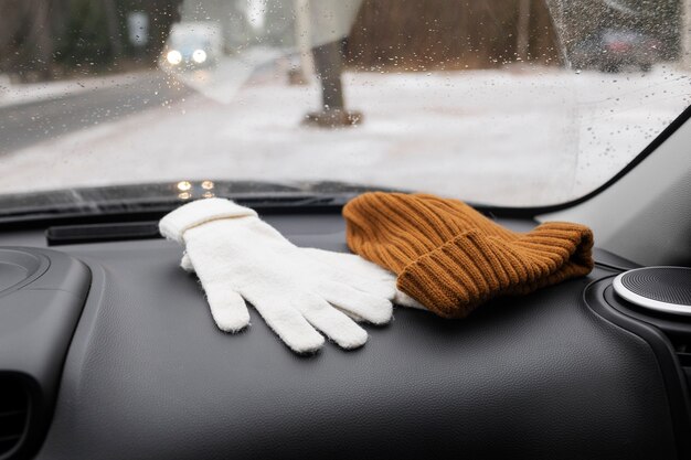 Foto guante y gorro en un coche durante el invierno.