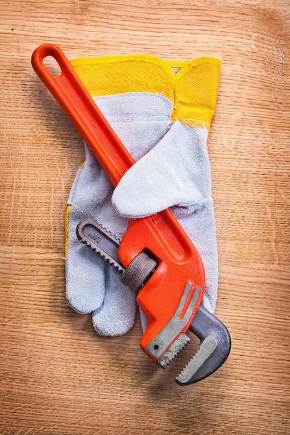 Guante de trabajo protector de llave inglesa en concepto de construcción de tablero de madera