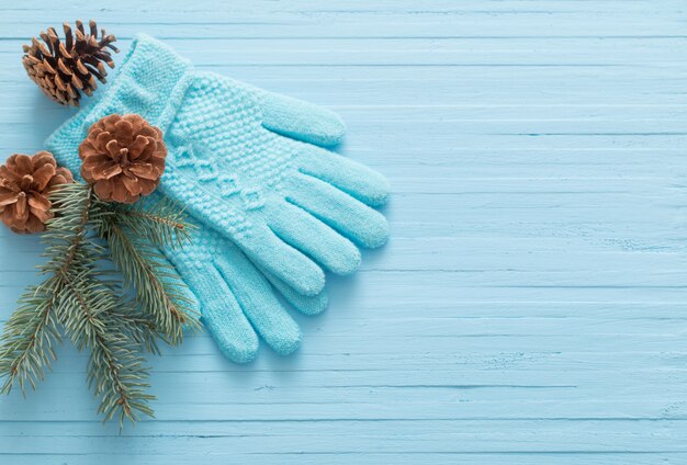 Foto guantes azules y abeto de navidad sobre fondo de madera