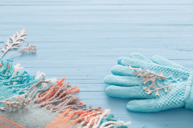 Guantes azules y bufanda sobre fondo de madera