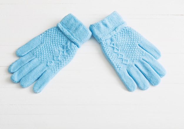 Guantes azules sobre fondo blanco de madera