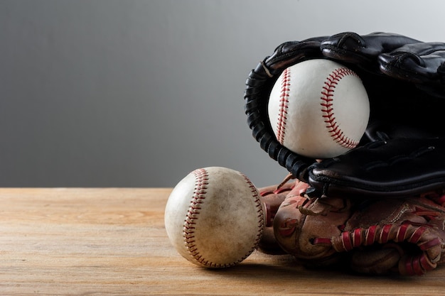 Guantes de béisbol y pelotas de béisbol en concepto de deporte de tablero de madera