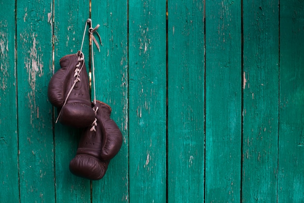 Guantes de boxeo colgados en la pared de madera vieja