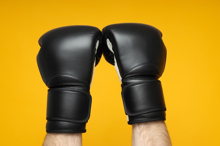 Guantes de boxeo negros sobre fondo amarillo