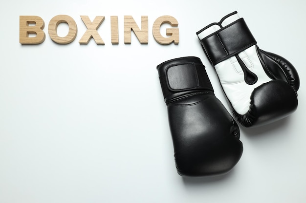 Guantes de boxeo negros sobre un fondo blanco.