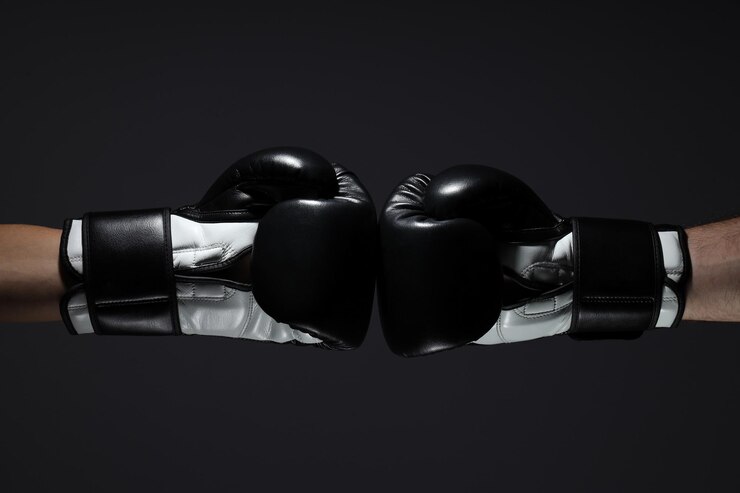 Guantes de boxeo negros sobre un fondo oscuro