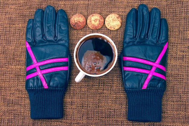 Guantes de cuero junto a una taza de café caliente. bebidas calientes