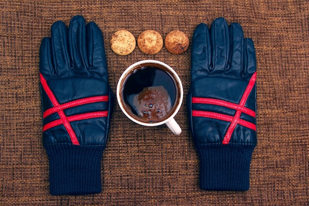 Guantes de cuero junto a una taza de café caliente.