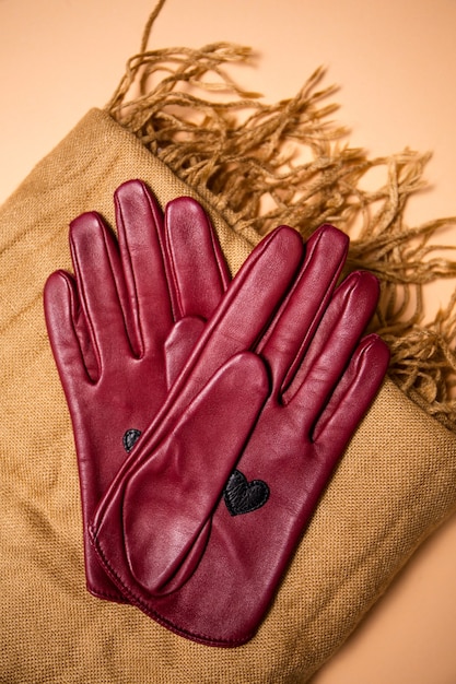 Foto guantes de cuero rojo con estilo en una bufanda, vista superior