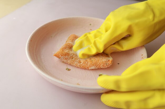 Foto guantes de goma esponja y plato colorido en azul.