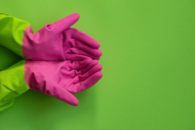 guantes de goma rosa sobre fondo verde