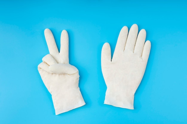 Foto guantes de látex blancos. concepto de protección. con la protección adecuada, vence al virus.