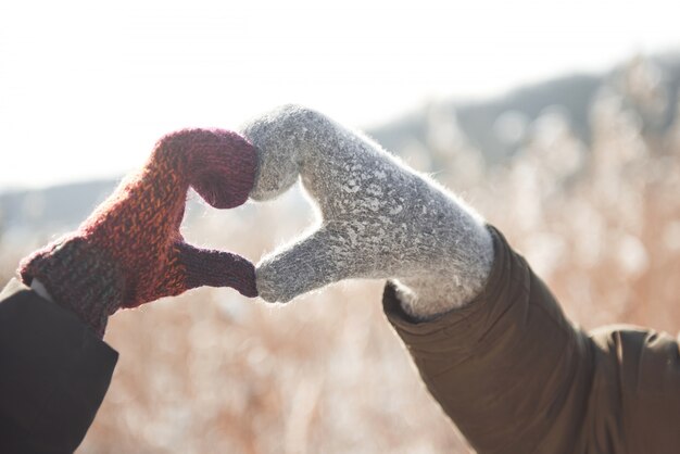 Guantes de mujer y hombre con guantes doblados en forma de corazón. Concepto de invierno Nevada.