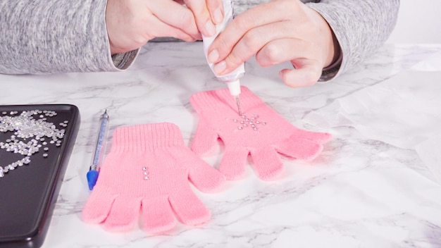 Guantes de niños rosa strass con formas de copos de nieve.