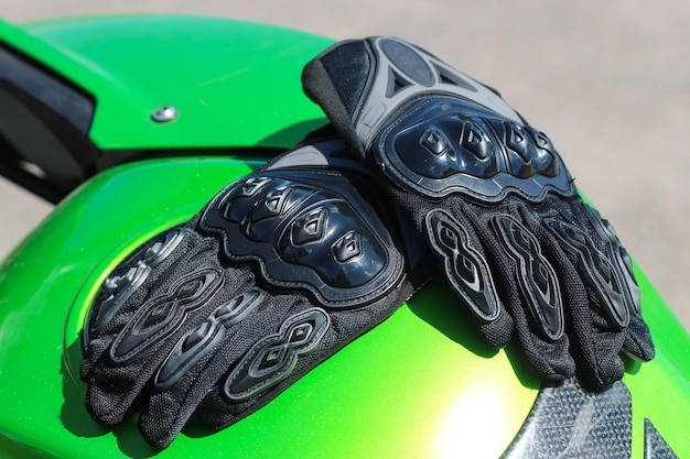 Guantes de protección negros para motociclista con inserciones de plástico.