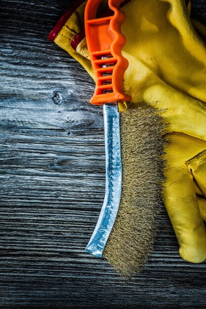 Guantes protectores de cepillo de alambre de mano en tablero de madera vintage