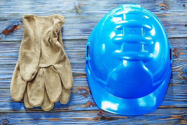 Guantes protectores de cuero construyendo casco en tablero de madera vintage