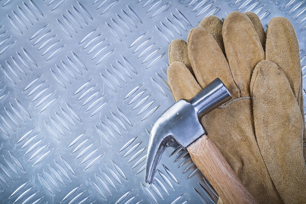 Guantes protectores de cuero de martillo en concepto de construcción de fondo de metal estriado