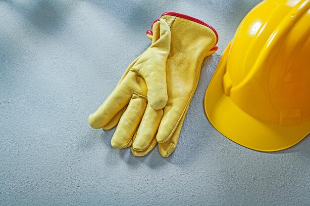 Guantes protectores de tapa de seguridad en concepto de construcción de superficie de hormigón