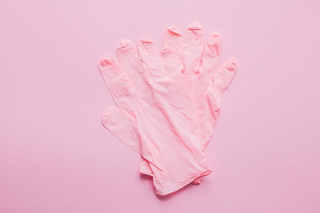 Guantes rosados sobre fondo rosa plano Lay Pandemia de coronavirus Manténgase seguro Prevención de la epidemia de virus Compras seguras y caminar afuera en cuarentena Manténgase en casa vidas seguras