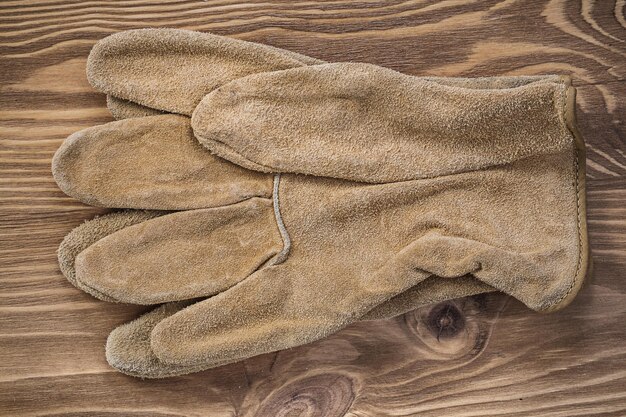 Guantes de seguridad en concepto de mantenimiento de tablero de madera vintage.