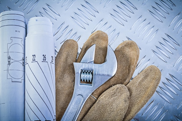 Guantes de seguridad laminados dibujos de ingeniería llave de tubo en concepto de construcción de fondo de metal ranurado