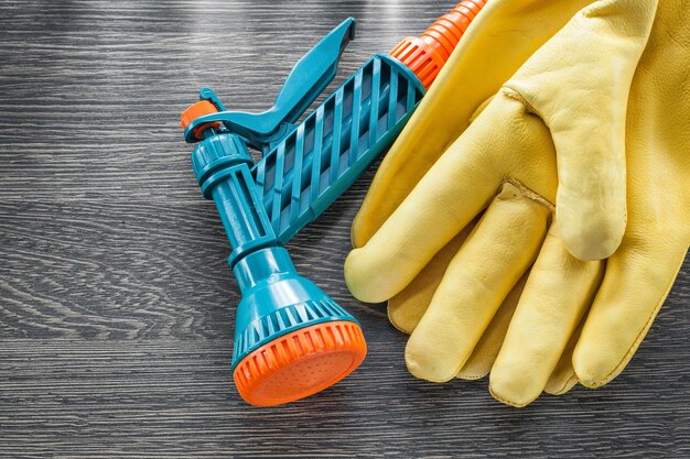 Guantes de seguridad de pistola de jardín sobre tabla de madera.