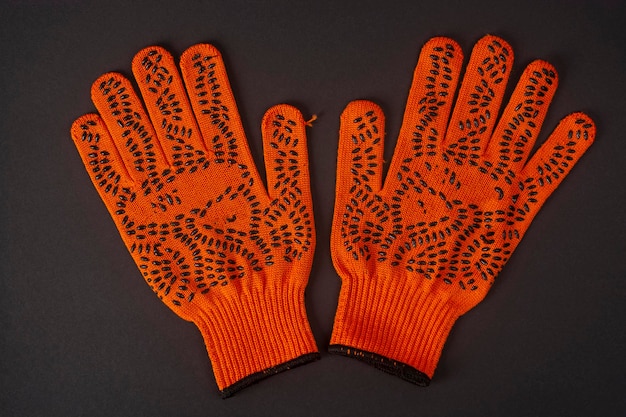 Guantes de trabajo naranja sobre fondo negro