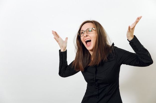 La guapa joven europea de pelo castaño enojado con gafas para la vista con piel sana y limpia, vestida con una camisa negra oscura, gritando y jurando, sobre un fondo blanco. Concepto de emociones.