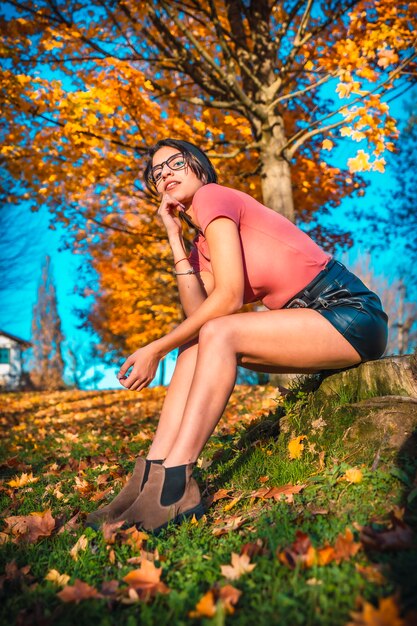 Una guapa morena con gafas en un tiroteo de otoño