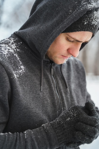 Guapo atlético vistiendo sudadera con capucha durante su entrenamiento de invierno