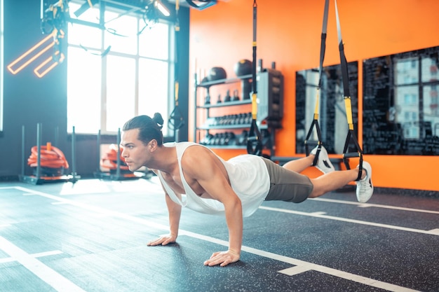 Foto guapo buen hombre en forma haciendo algunas flexiones