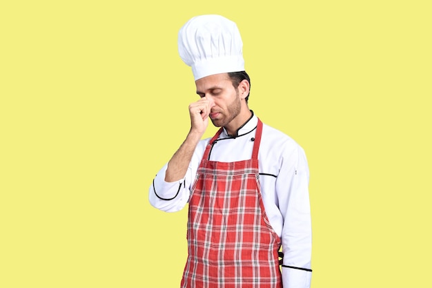 guapo chef cocinero traje blanco sobre fondo amarillo modelo indio paquistaní