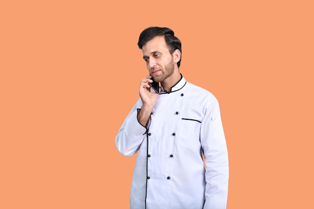 guapo chef hablando por teléfono traje blanco modelo pakistaní indio