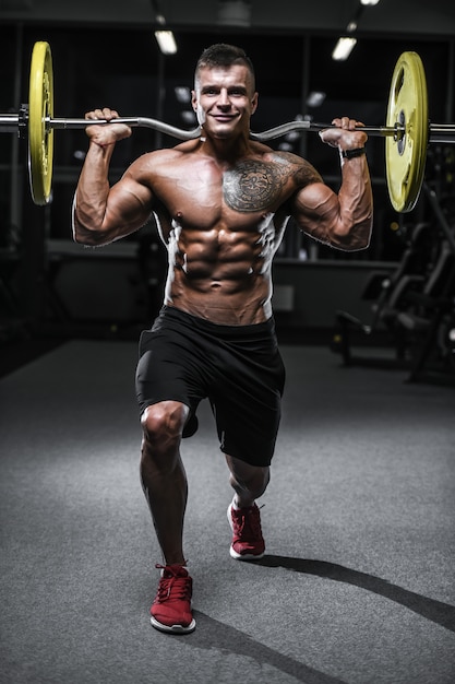 Guapo culturista fuerte atlético hombres bombeando músculos con pesas