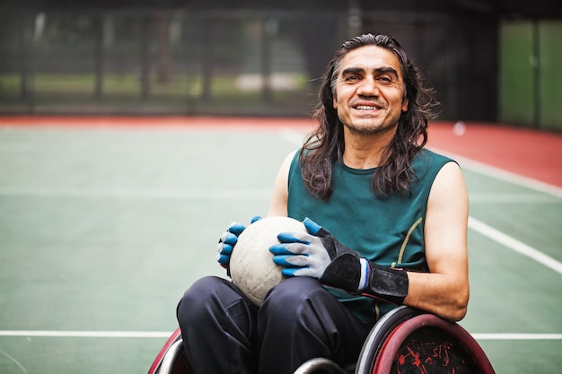 Guapo determinado jugador de rugby discapacitado en silla de ruedas en un estadio