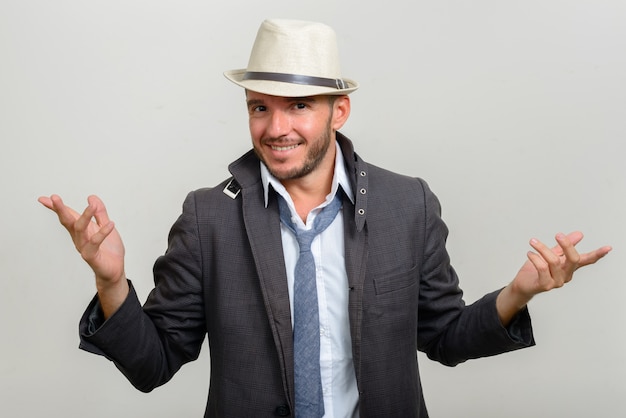 Guapo empresario hispano barbudo con sombrero en blanco